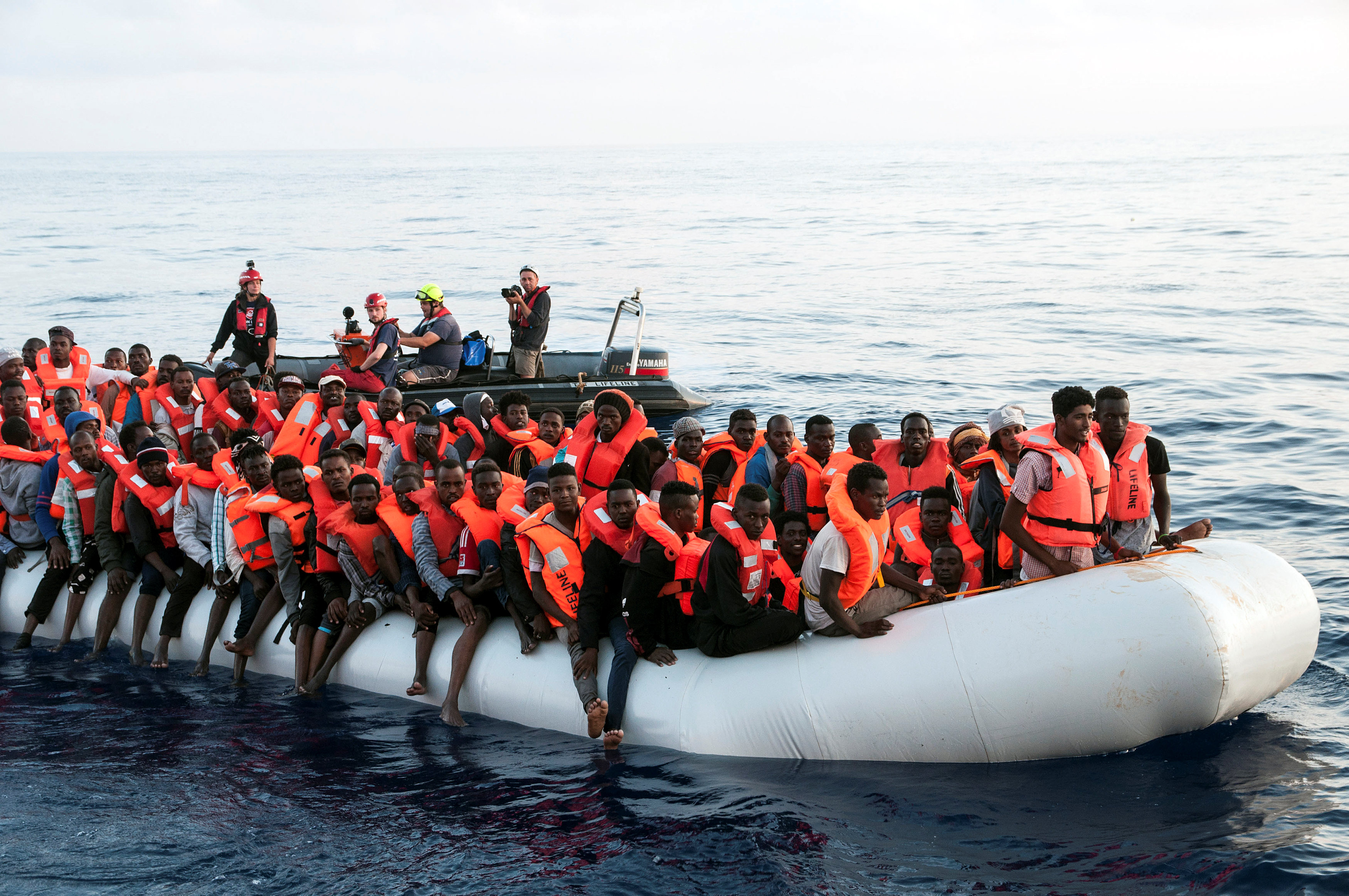 Migrants are seen in a rubber dinghy as they are rescued by the crew of the Mission Lifeline rescue boat in the central Mediterranean Sea