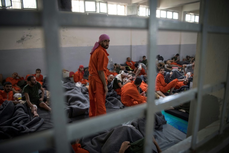 معتقلون من عناصر تنظيم الدولة الإسلامية يجلسون أرضاً في سجن تابع لقوات سوريا الديموقراطية