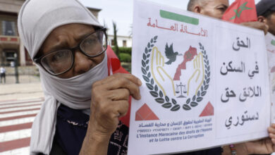 محتجة تحمل لافتة تنادي بالحق في السكن خلال تظاهرة للمطالبة بمساعدات حكومية لإعادة الاعمار في الرباط في الثامن من سبتمبر 2025