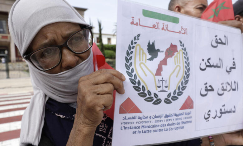 محتجة تحمل لافتة تنادي بالحق في السكن خلال تظاهرة للمطالبة بمساعدات حكومية لإعادة الاعمار في الرباط في الثامن من سبتمبر 2025